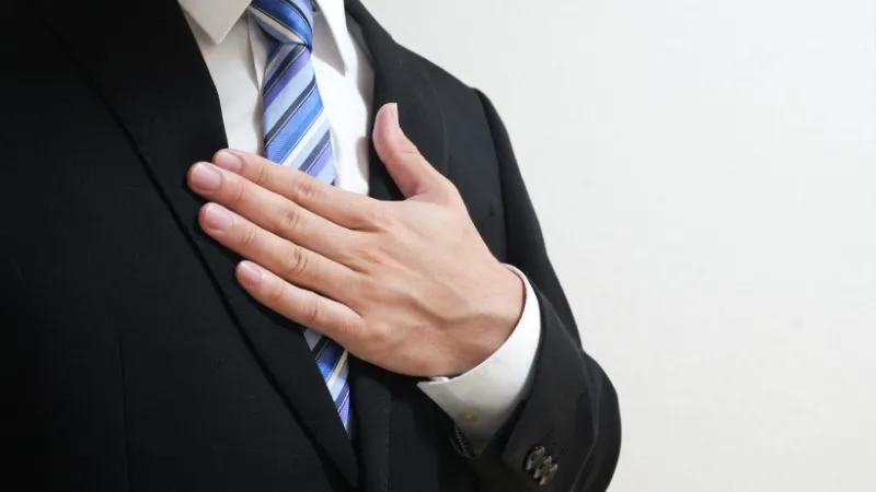 胸に手をあてる男性