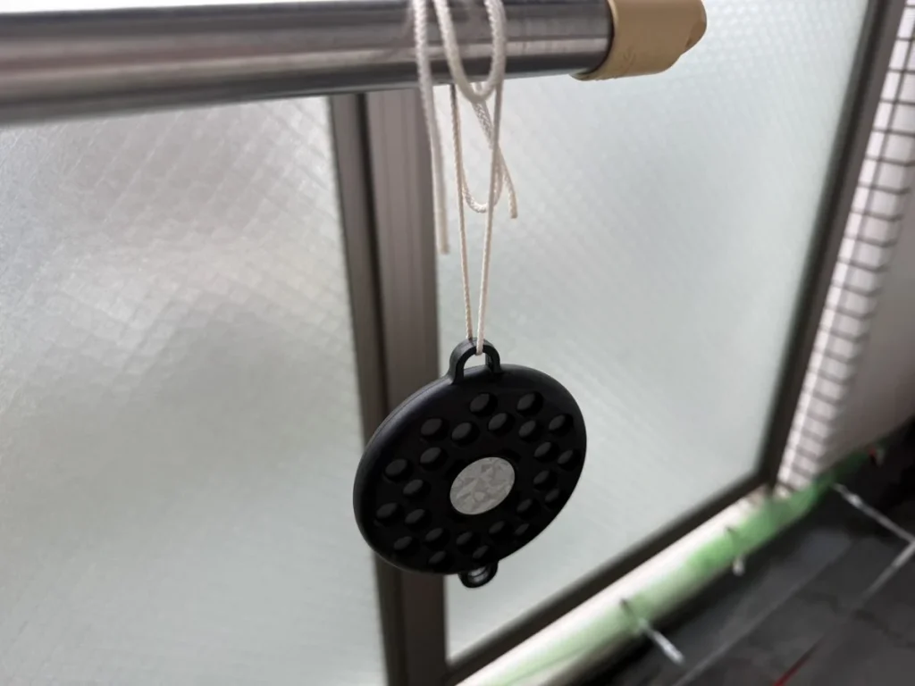 物干し竿から吊るした、黒くて丸い鳩よけのマグネット