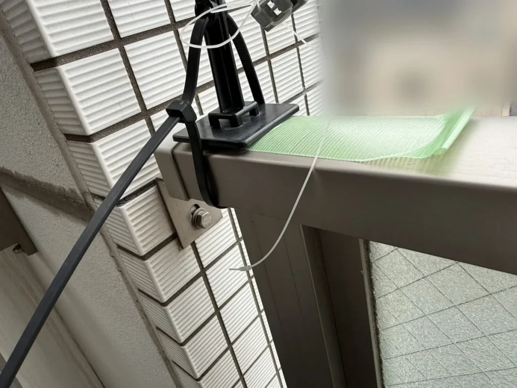 ベランダの手すりの角に固定したテグス